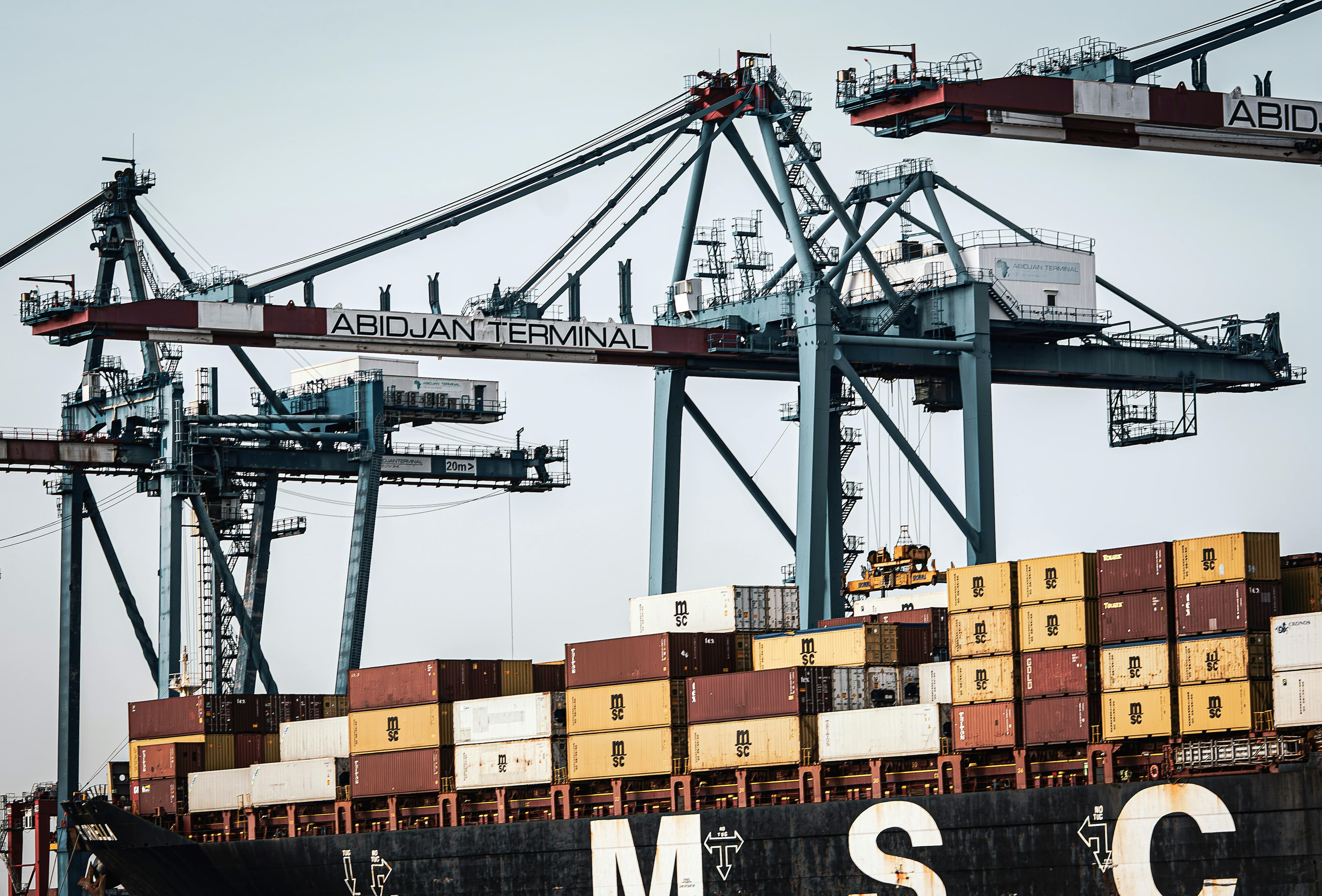 Inspector on container being lifted by crane